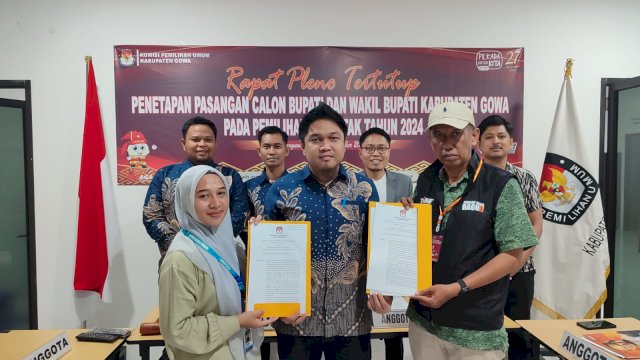 Ketua KPU Gowa Fitra Syahdanul (tengah) saat menyerahkan SK Penetapan Paslon kepada petugas penghubung paslon usai melaksanakan Rapat Pleno Tertutup dengan agenda Penetapan Pasangan Calon Bupati dan Wakil Bupati Kabupaten Gowa pada Pilkada Serentak 2024, di Kantor KPU Gowa, Minggu, (22/09/2024). (Dok. Humas KPU Gowa)