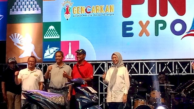 Hamka Karim, warga Kabupaten Gowa (kedua kanan) saat menerima grandprize motor, di sela-sela Penutupan FIN Expo BIK OJK 2024, di Anjungan MNEK Central Point of Indonesia (CPI) Makassar, Sabtu, (26/10/2024) malam kemarin. (Dok. Chaerani/Republiknews.co.id)