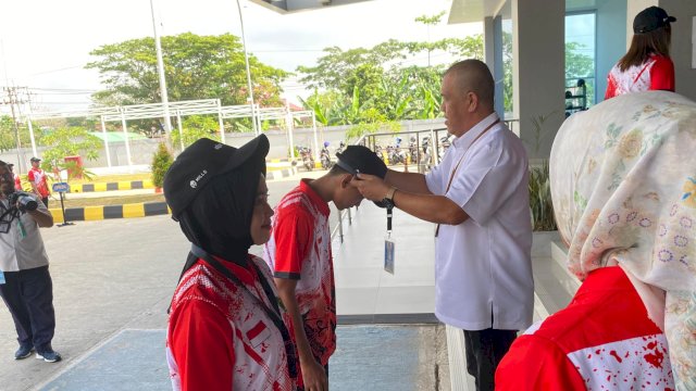 Kepala Bidang Pembudayaan Olahraga Dinas Pemuda dan Olahraga (Dispora) Kalimantan Timur (Kaltim) , AA Bagus Sugiarta saat memasangkan Id Card kepada atlet. (Dok.Republikanews.co.id / Nr)