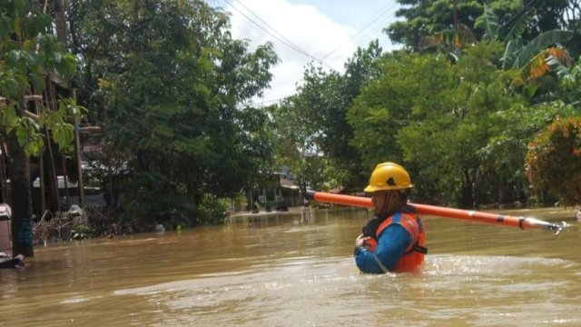 Petugas PLN saat menerjang banjir untuk mengamankan pasokan listrik di Kabupaten Maros, 12 Februari lalu. (Foto: Istimewa)