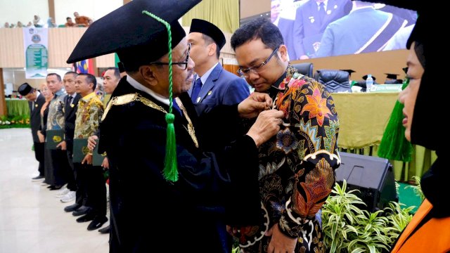 Wakil Bupati Gowa, Darmawangsyah Muin saat menerima pin emas dari Rektor UMI Makassar, Prof. Hambali Thalib, di sela-sela Perayaan Milad Ke-71 Tahun Universitas Muslim Indonesia (UMI) Makassar, di Auditorium Al Jibra, Kampus UMI, kemarin. (Dok. Humas Gowa)