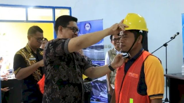 Wabup Bulukumba, Andi Edy Manaf memasang helm sebagai simbol sertifikasi tenaga konstruksi. [IST]
