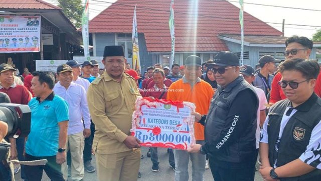 Kades Karang Tunggal, Solimin saat menerima penghargaan dari Bupati Kukar Aulia Rahman Basri. (IST)