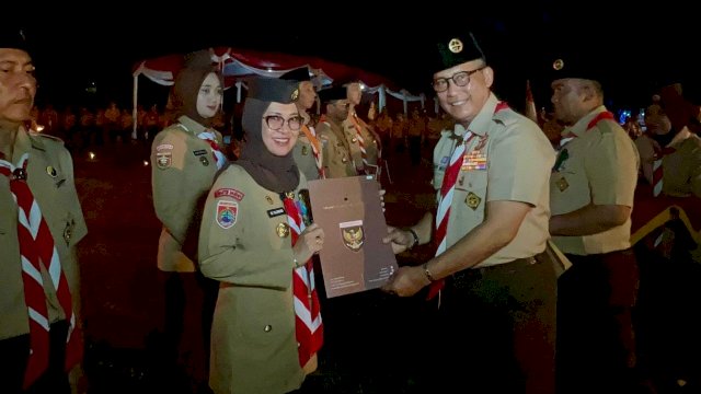 Bupati Gowa yang juga Ketua Majelis Pembimbing Cabang Gerakan Pramuka Gowa dan Ketua Kwartir Cabang Gerakan Pramuka Gowa, Sitti Husniah Talenrang saat menerima Tanda Penghargaan Lencana Darma Bakti dari Kwartir Nasional Gerakan Pramuka, Komjen Pol (Purn) Budi Waseso, di Buperta Cibubur, Rabu (13/08/2025) malam kemarin. (Dok. Humas Gowa) 