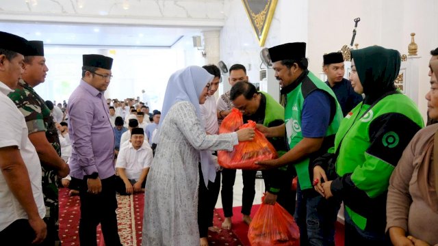 Bupati Gowa Sitti Husniah Talenrang didampingi Wakilnya Darmawangsyah Muin saat menyerahkan paket sembako ke salah satu drivel ojol, di sela-sela pelaksanaan Tausyiah, Zikir dan Doa Bersama masyarakat dan komunitas driver ojol, di Masjid Agung Syekh Yusuf, kemarin. (Dok. Humas Gowa) 