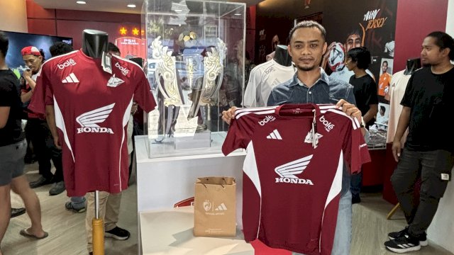 Salah seorang suporter PSM Makassar memamerkan jersey home edisi player issue yang dijual di store resmi yang terletak di Jalan Balaikota, Makassar mulai Kamis (18/9/2025). (Foto: Istimewa)
