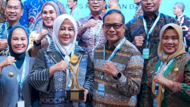 Wakil Gubernur Sulawesi Selatan, Fatmawati Rusdi bersama Kepala OJK Sulselbar, Moch Muchlasin berfoto bersama usai menerima penghargaan TPAKD Terbaik Tingkat Provinsi, di sela-sela Rapat Koordinasi Nasional (Rakornas) TPAKD 2025, di Jakarta, kemarin. (Dok. Istimewa)