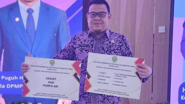 Kepala DPMD Kukar, Arianto menerima bantuan dari DPMD Provinsi Kaltim. [Istimewa]