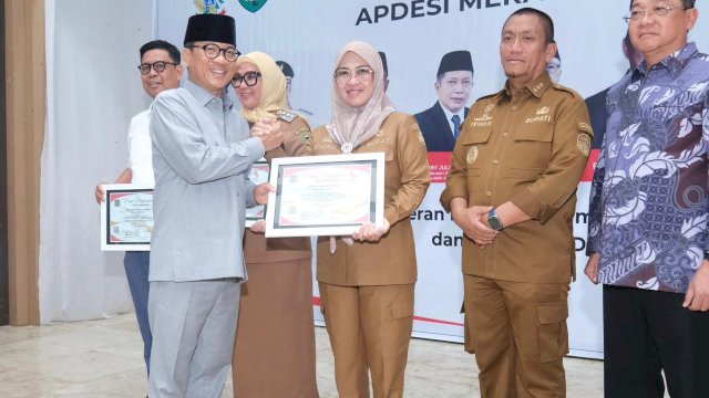 Bupati Gowa, Sitti Husniah Talenrang saat menerima Penghargaan APDESI Merah Putih dari Menteri Desa dan Pembangunan Daerah Tertinggal, Yandri Susanto pada kegiatan Saba Desa APDESI Merah Putih se-Wilayah Sulawesi, di Gedung Serbaguna Kabupaten Maros, kemarin. (Dok. Humas Gowa)