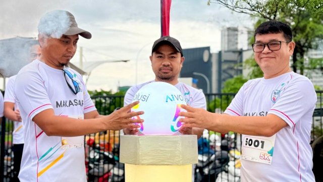 EVP Head of Circle Kalisumapa Indosat Ooredoo Hutchsion, Swandi Tjia (kanan) saat memperkenalkan teknologi AIvolusi5G, di sela-sela AIvolusi5G Fun Run, di wilayah CPI Makassar, Minggu, (21/12/2025) pagi tadi. (Dok. Indosat) 
