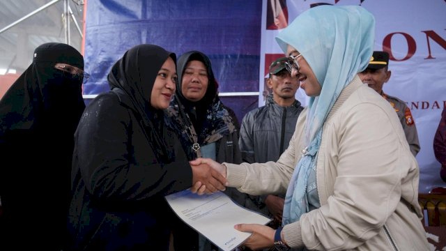 Bupati Gowa, Sitti Husniah Talenrang saat memberikan sertifikat PTSL secara simbolik kepada salah satu warga pada rangkaian One Day One District, di Pasar Wisata Mandiri Pattapang, Kecamatan Tinggimoncong, Jumat (16/01/2026). (Dok. Humas Gowa) 
