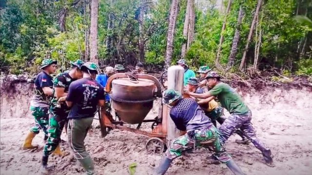 Satgas TMMD Berjibaku Angkut Material di Jalur Berlumpur Batangmata Sapo. [IST]