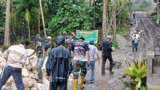 Diguyur Hujan, Warga dan Satgas TMMD Selayar Tetap Gotong Royong Bangun Drainase Jalan Tani. [IST]