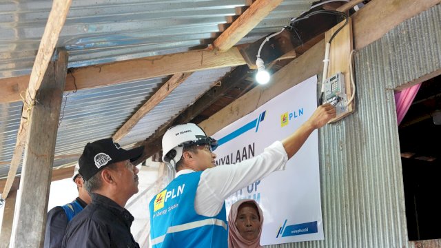 General Manager PLN UIP Sulawesi, I Gusti Made Aditya San Adinatha bersama Ibu Daeng Kanang (jilbab pink) saat seremoni penyalaan listrik secara simbolis dilaksanakan pada Sabtu, 23 Mei 2026, di Dusun Pangajiang, Desa Parigi, Kecamatan Tinggimoncong, Kabupaten Gowa. (Dok. Humas PLN UIP Sulawesi) 