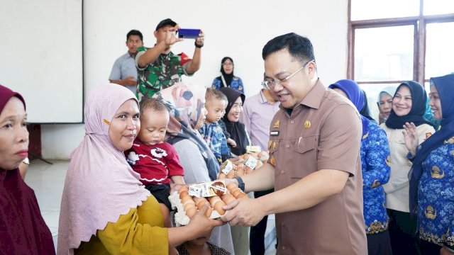 Wabup Gowa Darmawangsyah Muin saat memberikan secara simbolik bantuan makanan bergizi kepada keluarga berisiko stunting di Kecamatan Bajeng, kemarin. (Dok. Humas Gowa) 