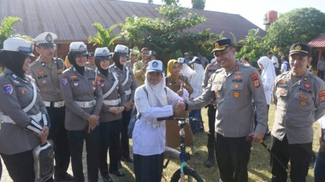 Kapolres Bulukumba, AKBP Restu Wijayanto memberikan hadiah sepeda kepada salah satu siswa pada kegiatan penyambutan hari pertama masuk sekolah tahun ajaran baru 2026/2027 di SMP N 1 Bulukumba. [IST]