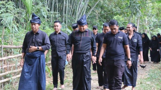 Kapolres Bulukumba AKBP Stephanus Luckyto Andri Wicaksono bersama rombongan berjalan tanpa alas kaki mengenakan pakaian adat serba hitam saat mengunjungi kawasan adat Ammatoa Kajang, Kabupaten Bulukumba. [IST]