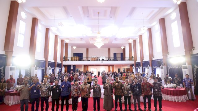 Kepala Eksekutif Pengawas PVML OJK, Agusman (tengah) bersama Wakil Gubernur Sulsel, Fatmawati Rusdi (sisi kanan) dan Kepala OJK Sulselbar, Moch. Muchlasin (sisi kiri) dan pejabat terkait lainnya berfoto bersama pada Workshop Penguatan Kapasitas TPAKD Tahun 2026 yang dirangkaikan dengan penandatanganan Nota Kesepahaman Pengembangan Ekonomi Daerah Komoditas Kakao, di Aula Asta Cita, di Rumah Jabatan Gubernur Sulawesi Selatan, kemarin. (Dok. Otoritas Jasa Keuangan) 