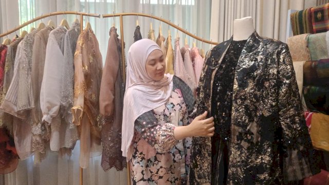 Owner EIWA, Alvira Ramdhani, memperkenalkan salah satu busana rancangannya yang ditampilkan pada Istanbul Fashion Connection (IFCO) 2026, di Turki beberapa waktu lalu saat disambangi di butiknya, di Jalan Deposito, Tello Baru, Senin, (01/09/2026) kemarin. (Dok. Chaerani/Republiknews.co.id)