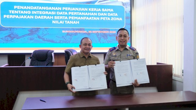 Kepala Bapenda Kabupaten Gowa, Indra Wahyudi Yusuf dan Kepala BPN Kabupaten Gowa, Aksara Alif Raja saat melakukan penandatanganan kerjasama, di Ruang Rapat Kantor Bapenda Kabupaten Gowa. (Dok. Humas Gowa) 