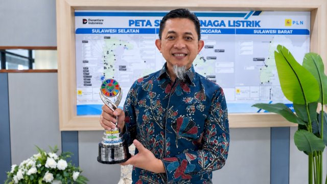 General Manager PLN UID Sulselrabar, Edyansyah, menunjukkan trofi Silver CSR dan PDB Awards 2026 yang diraih melalui program Kampung Energi Mandiri Saukang. (Foto: Istimewa)